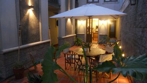 An outdoor patio with a round table and chairs, surrounded by potted plants. -  Posada Gotan (Buenos Aires)