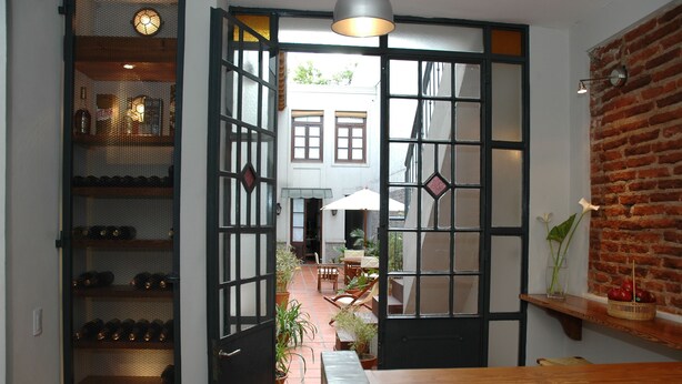 A traditional Japanese-style interior with tatami flooring, a low wooden table, and a sliding door leading to an outdoor patio area. -  Posada Gotan (Buenos Aires)