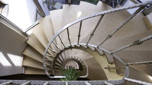 A spiral staircase with a metal railing and beige steps. - Altstadthotel Grauer Wolf (Erlangen)