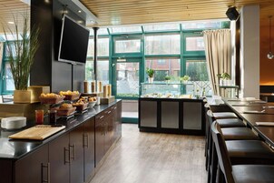 Una cocina moderna con una barra americana, ventanas amplias y vistas al exterior.