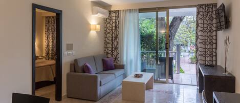 A modern living room with a sofa, coffee table, and a TV mounted on the wall.