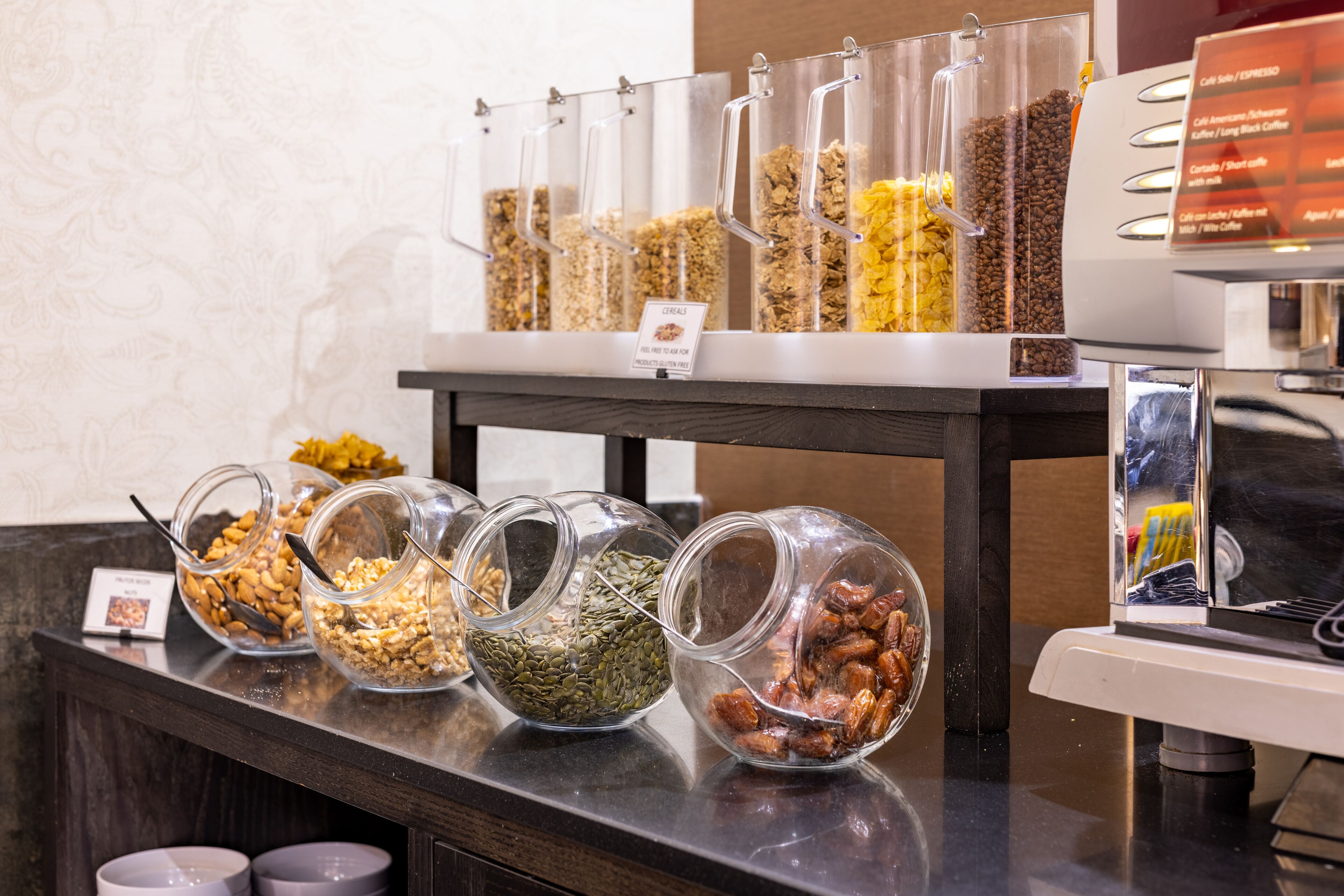 Un bufé con diversas opciones de comida en recipientes transparentes.
