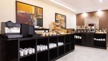 Eine moderne Kaffeestation mit Espressomaschinen, Brötchenkorben sowie verschiedenen Tassen und Bechern.