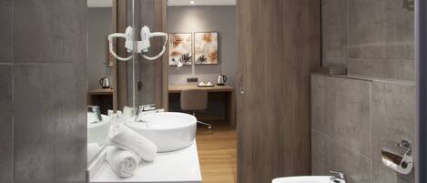 Une salle de bain moderne avec deux lavabos, un miroir et un espace douche.