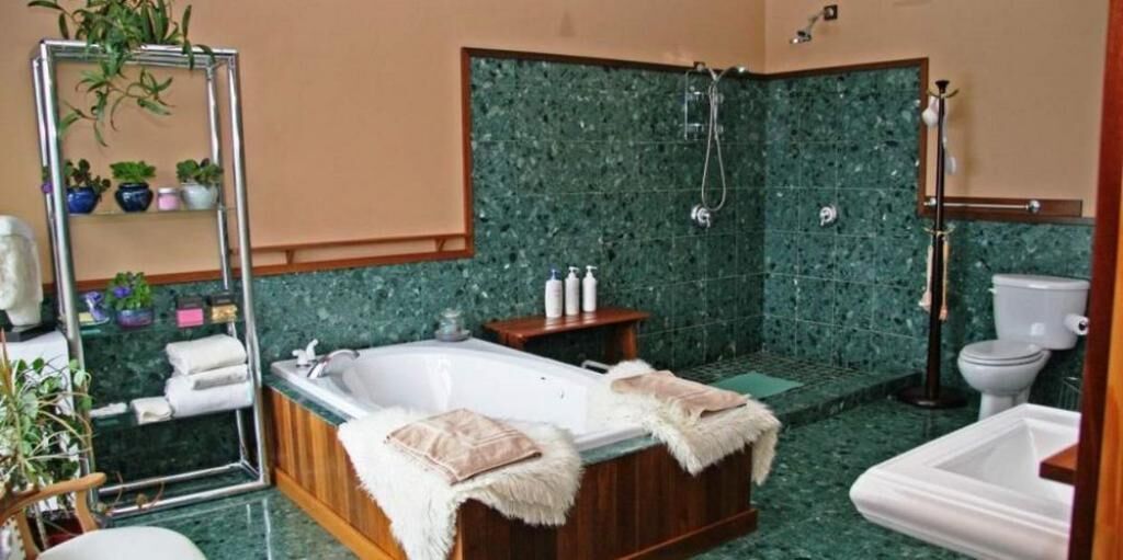 Un baño con una bañera independiente, ducha y retrete.