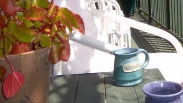 Un tavolo con una pianta in vaso, una tazza blu e un oggetto bianco.