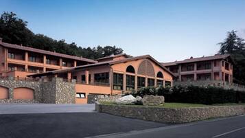 A multi-story hotel with a stone facade, large windows, and a central arched entrance.