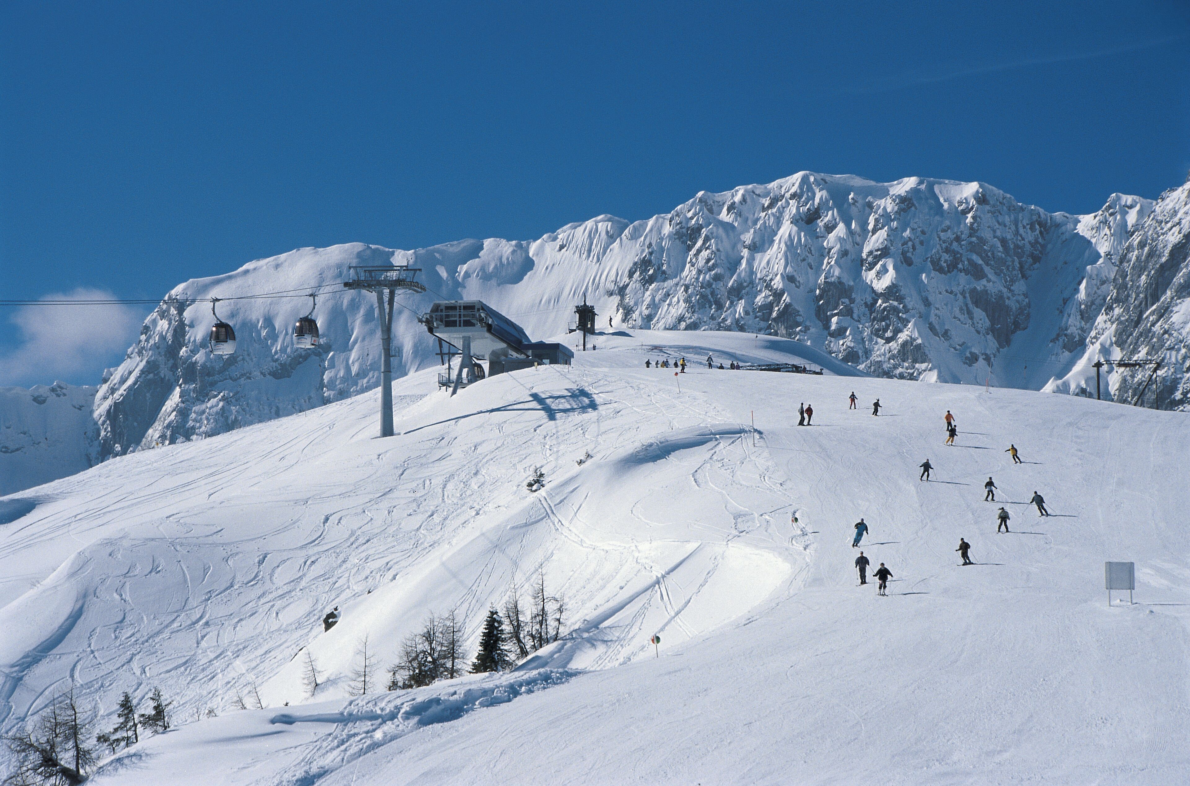 Ein verschneiter Skipisten mit Skilift und Bergblick.