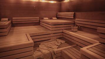 A sauna with multiple benches and a towel on the floor.