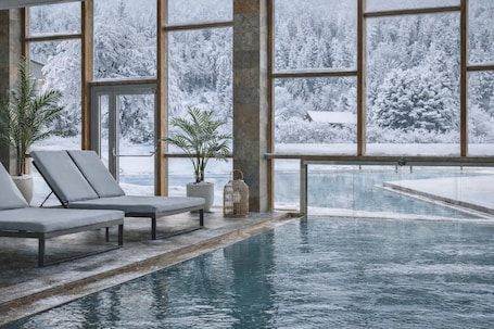 Una piscina techada, una piscina al aire libre, sombrillas. Falkensteiner Hotel & Spa Carinzia l 4 Star Superior