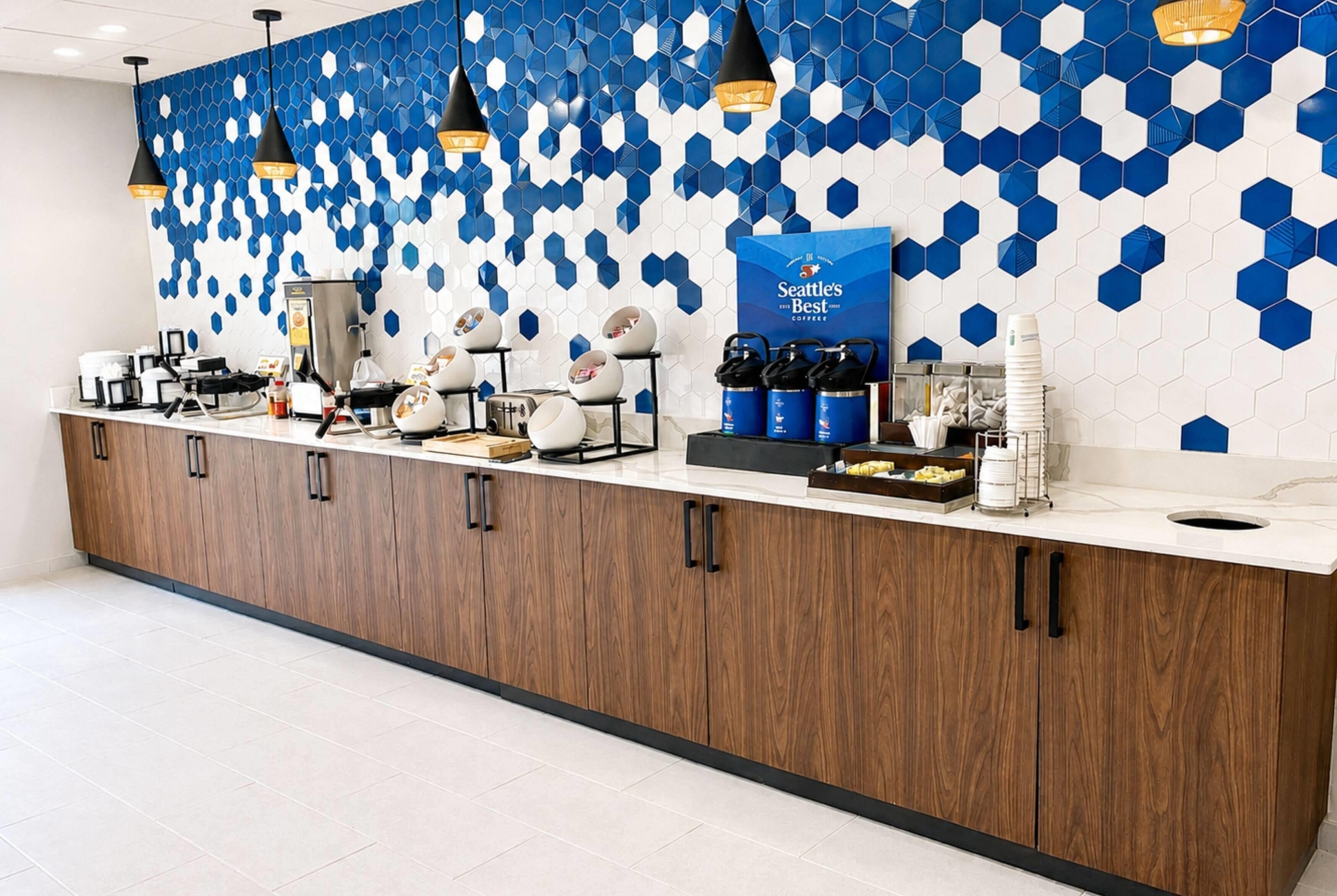 A hotel reception area with a counter, coffee machines, and a Seattle's Best Coffee sign.