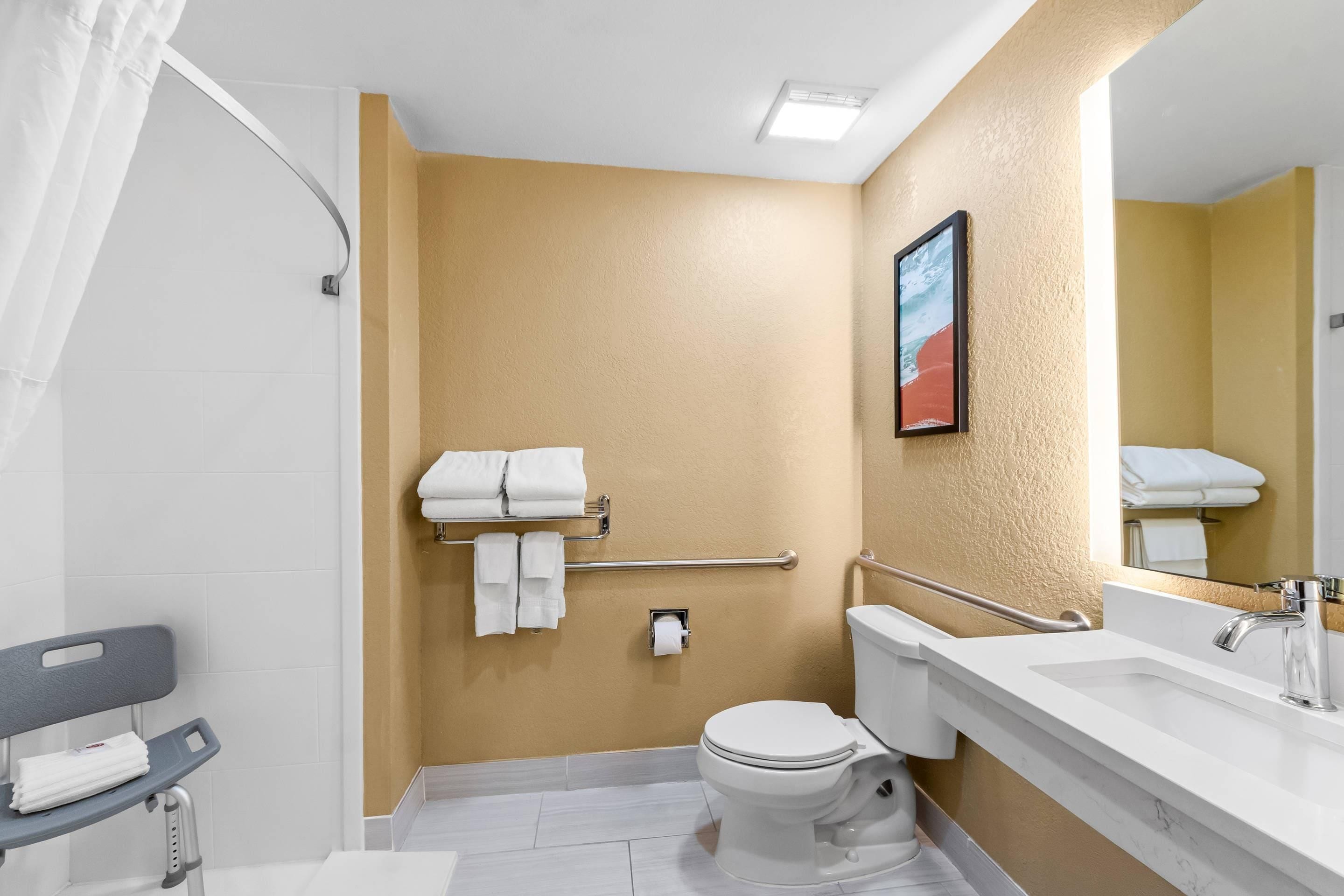 A bathroom with a toilet, sink, and shower area.