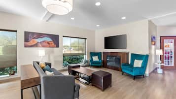 Una sala moderna con sofá, sillón, mesa de centro y chimenea.