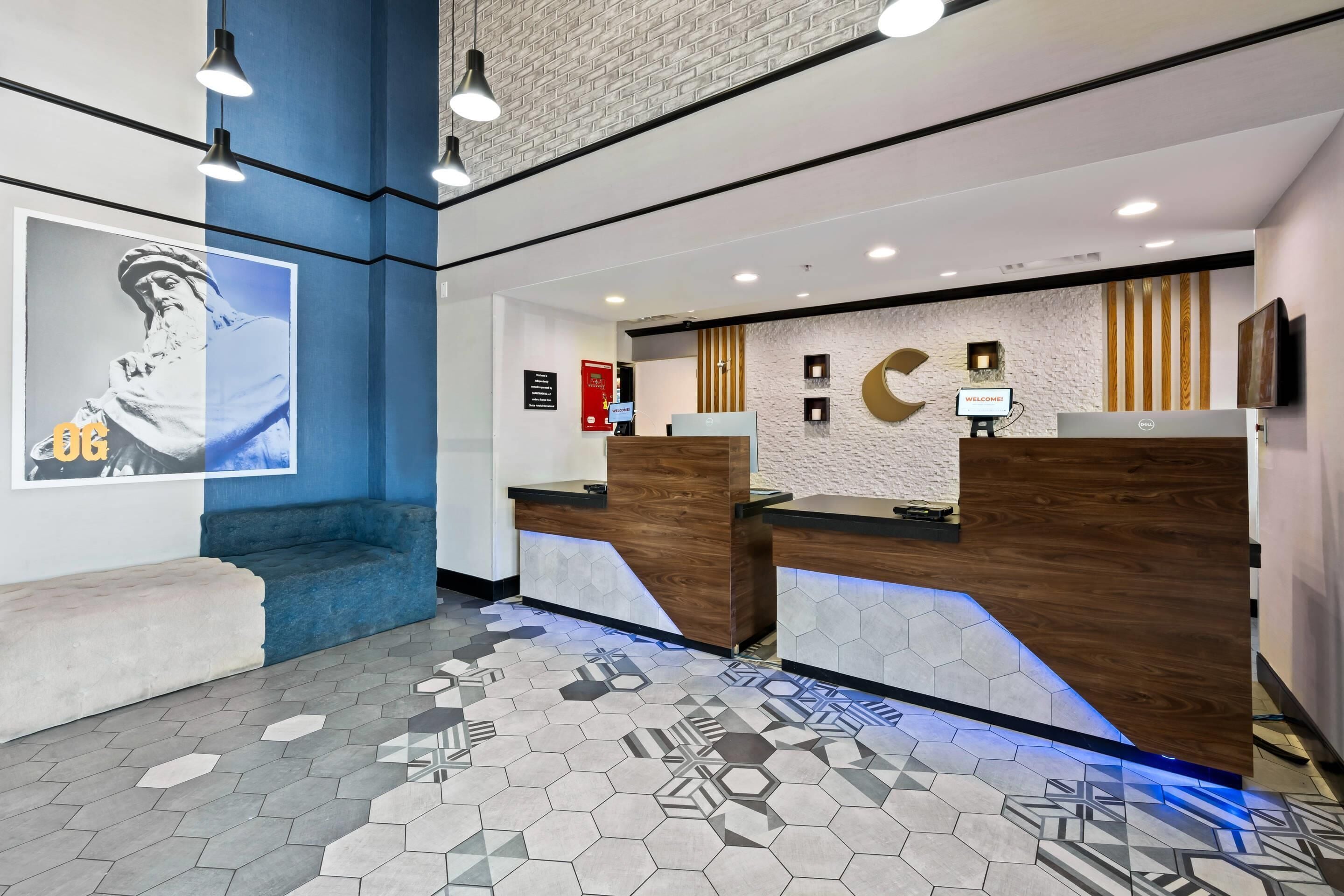 A reception area with a modern design, including a reception desk, a bench, and a wall-mounted TV.