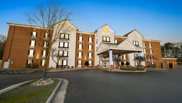 Et hotel med en central indgang, flere etager og en murstensfacade.