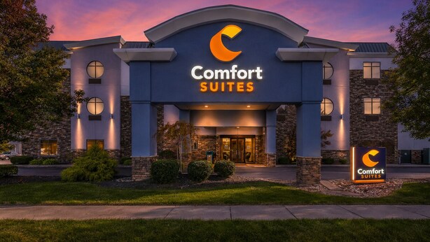 A hotel with a large sign reading 'Comfort Suites' and a logo above the entrance.