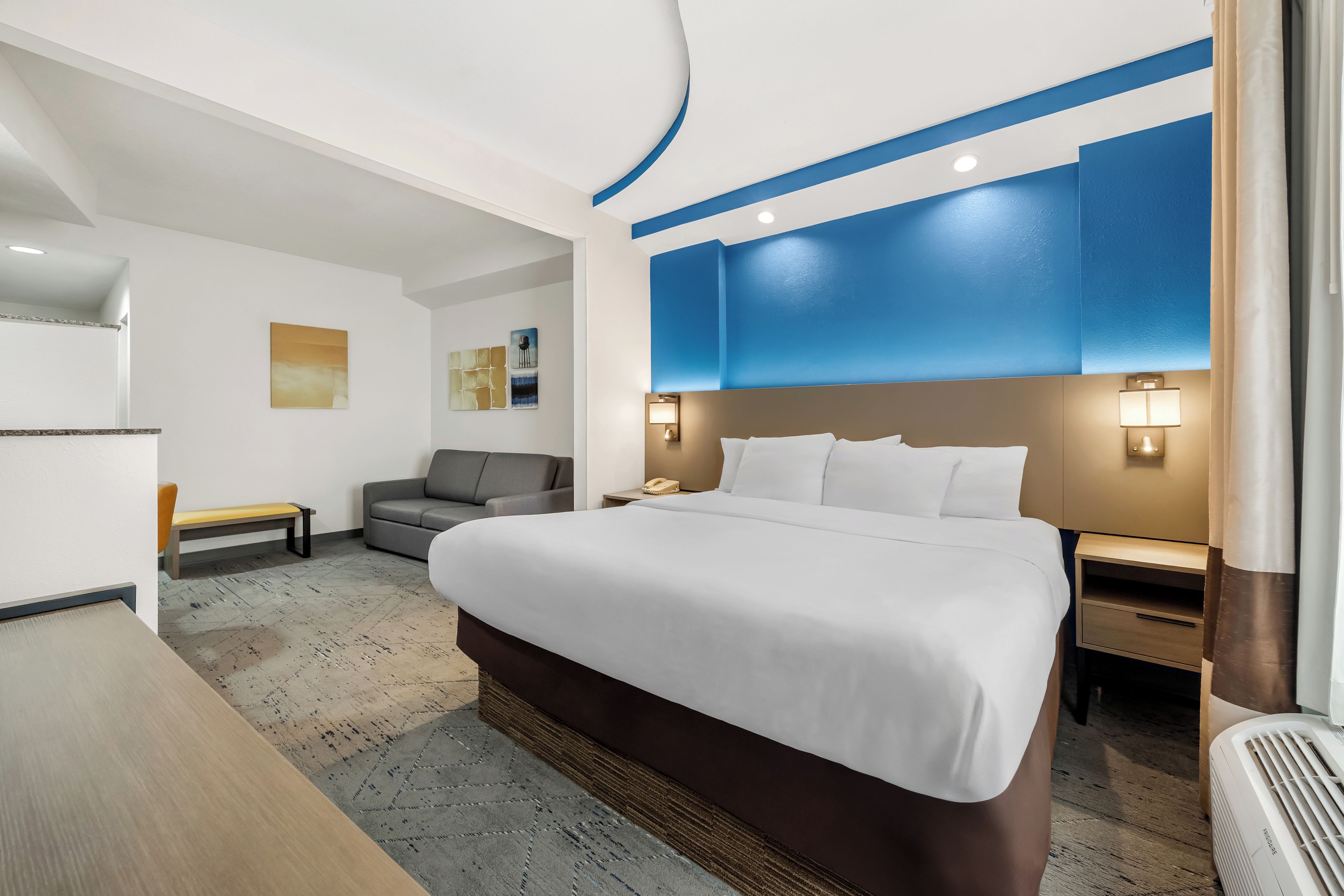 Een hotelkamer met een groot bed, een bureau, een stoel en een bank.