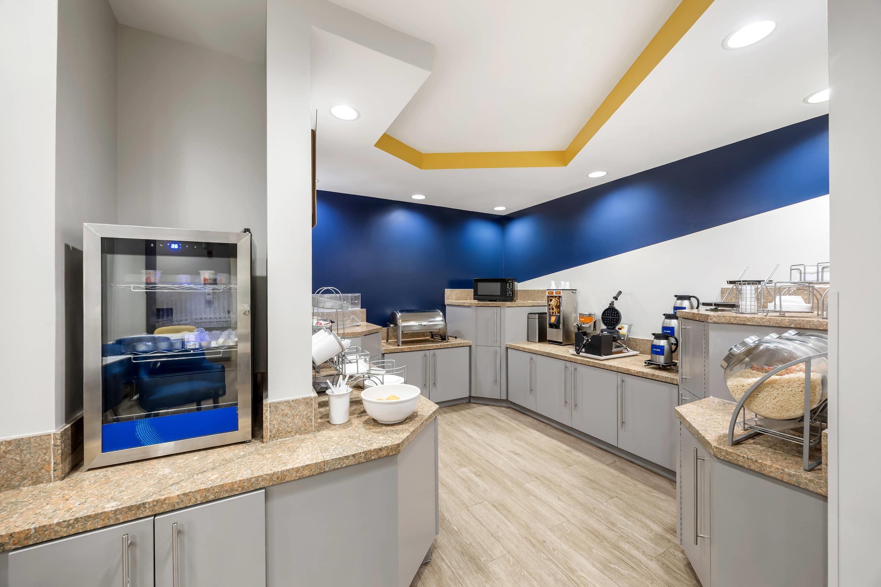 A modern kitchen with a built-in refrigerator, microwave, and coffee machine.