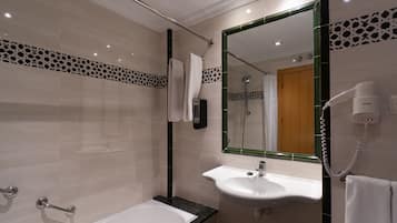 Un baño moderno con bañera, lavabo y espejo.