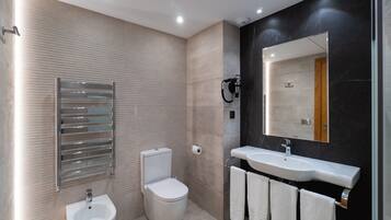 Un baño moderno con inodoro, bidé y lavamanos.
