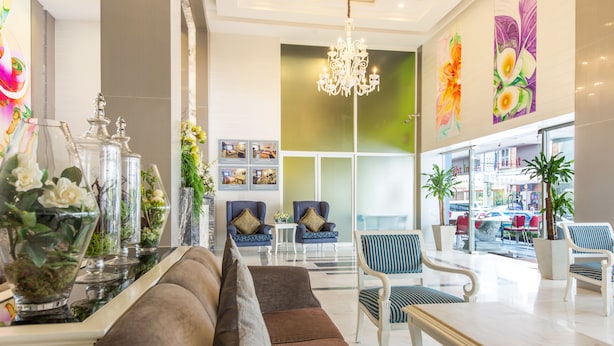 A modern lobby with a sofa, chairs, a table, and a chandelier. - Pratunam City Inn (Bangkok)