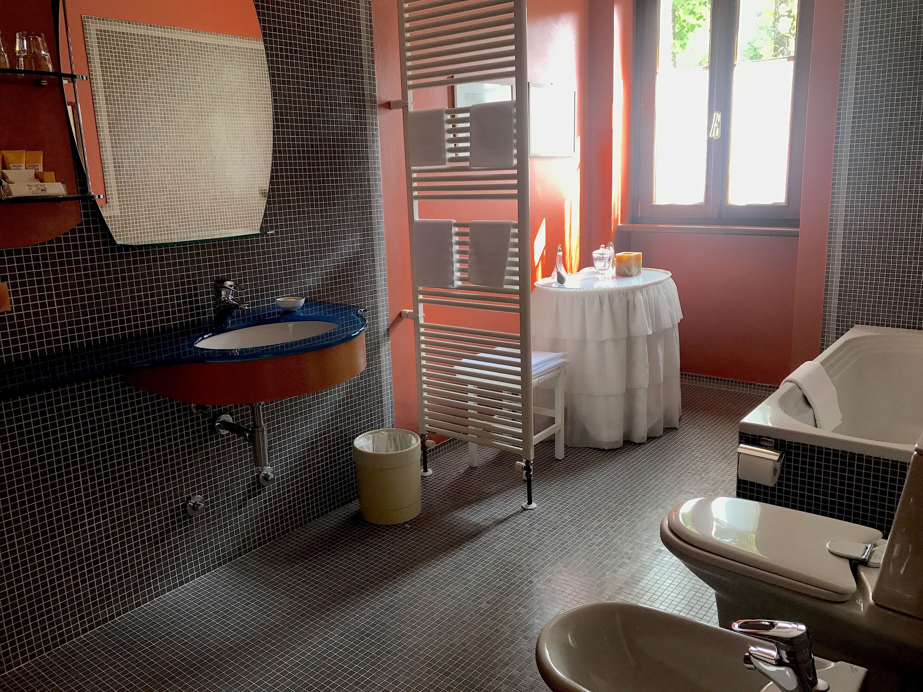 A bathroom with a blue sink, a white toilet, and a bathtub.