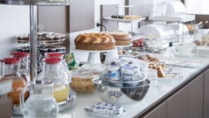 Ein Buffet mit verschiedenen Speisen, darunter Kuchen, Gebäck und Früchte.