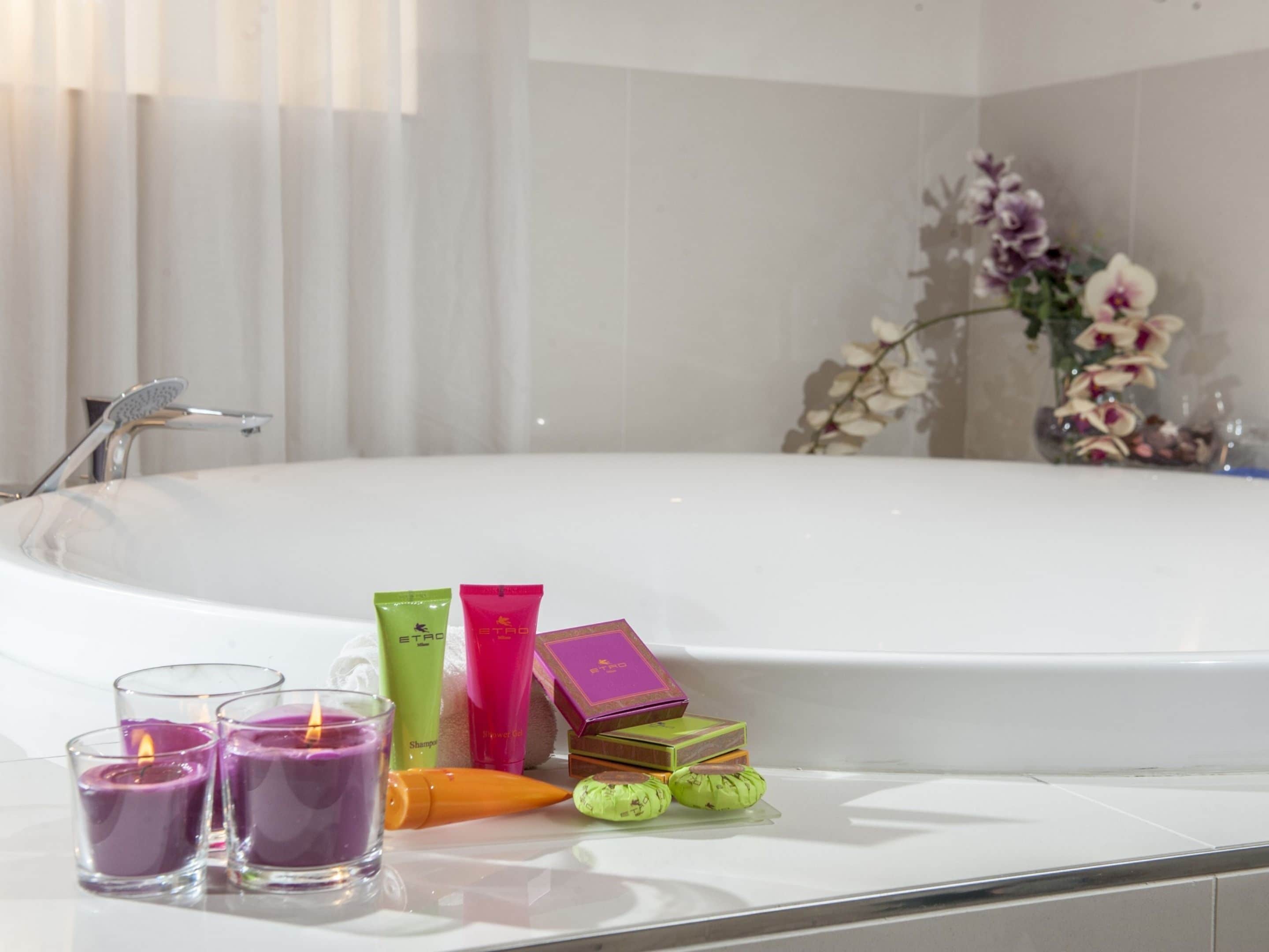 Un bagno con una vasca, un mobile per il bagno con articoli da toilette e uno specchio.