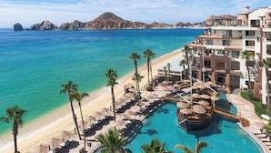 Un resort con piscina, playa y vista al océano.