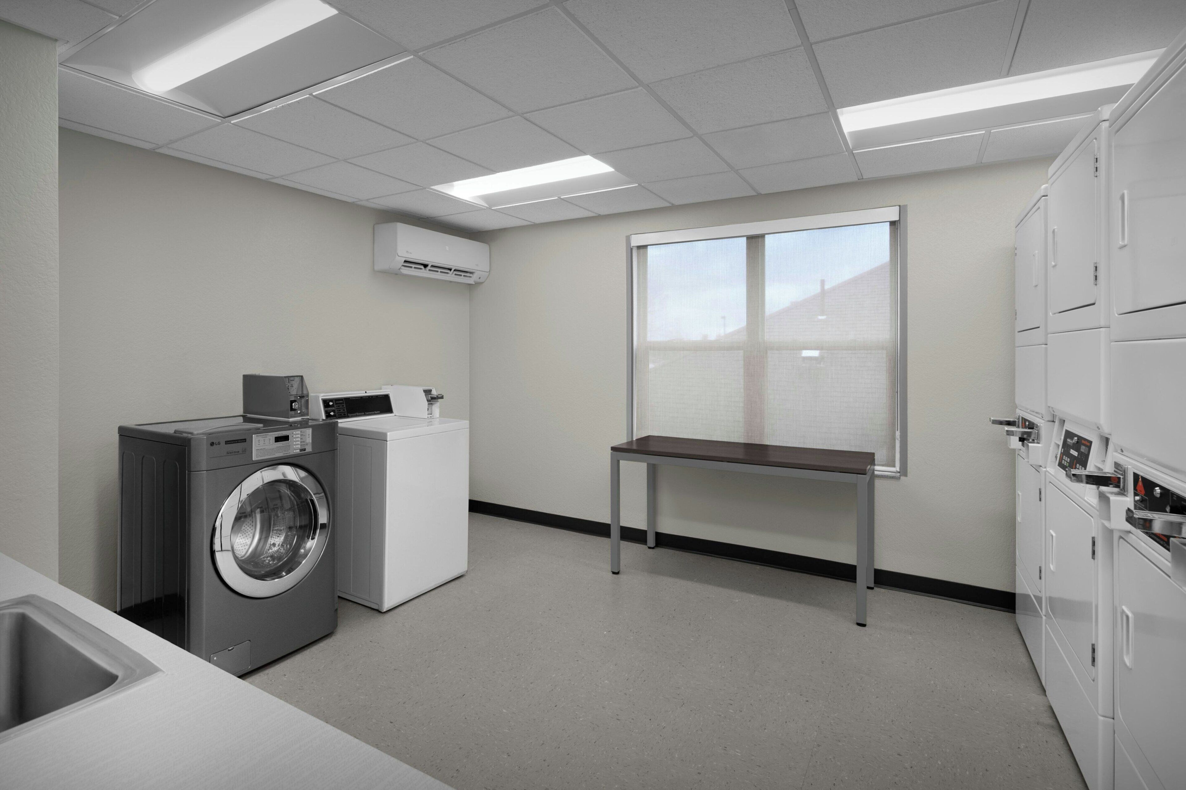 A laundry room with a washing machine, dryer, and stacked cabinets.