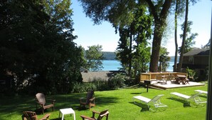 Ein Garten mit einer Terrasse, die auf einen See blickt, umgeben von Bäumen.