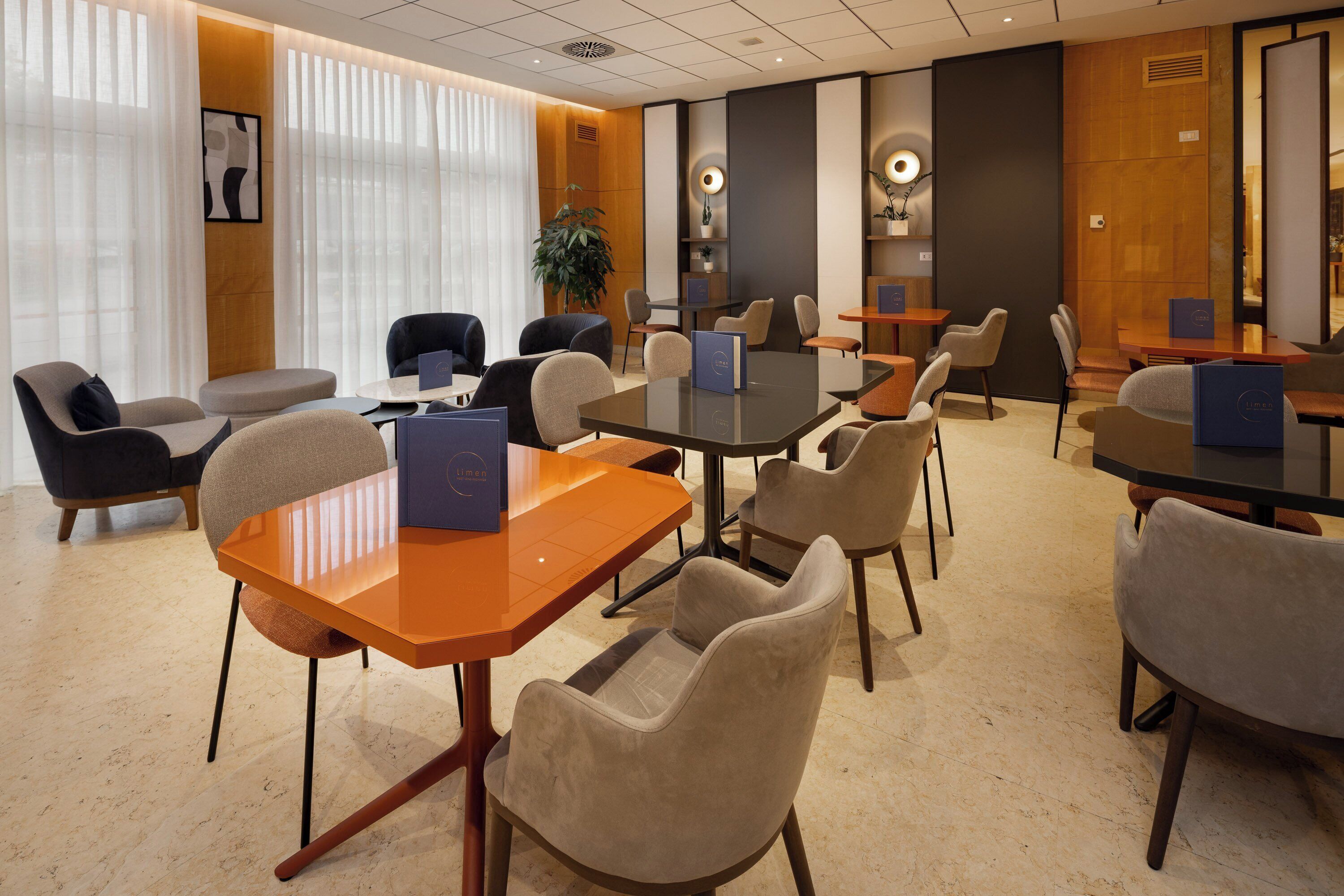 A modern conference room with a large table, multiple chairs, and a potted plant.