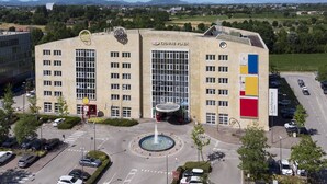 A large building with a central courtyard, multiple floors, and a parking area. - Crowne Plaza Padova by IHG (Padova)