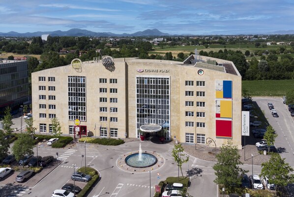 A large building with a central courtyard, multiple floors, and a parking area. - Crowne Plaza Padova by IHG (Padova)
