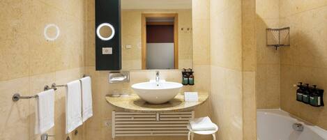 A modern bathroom with a sink, bidet, and bathtub.