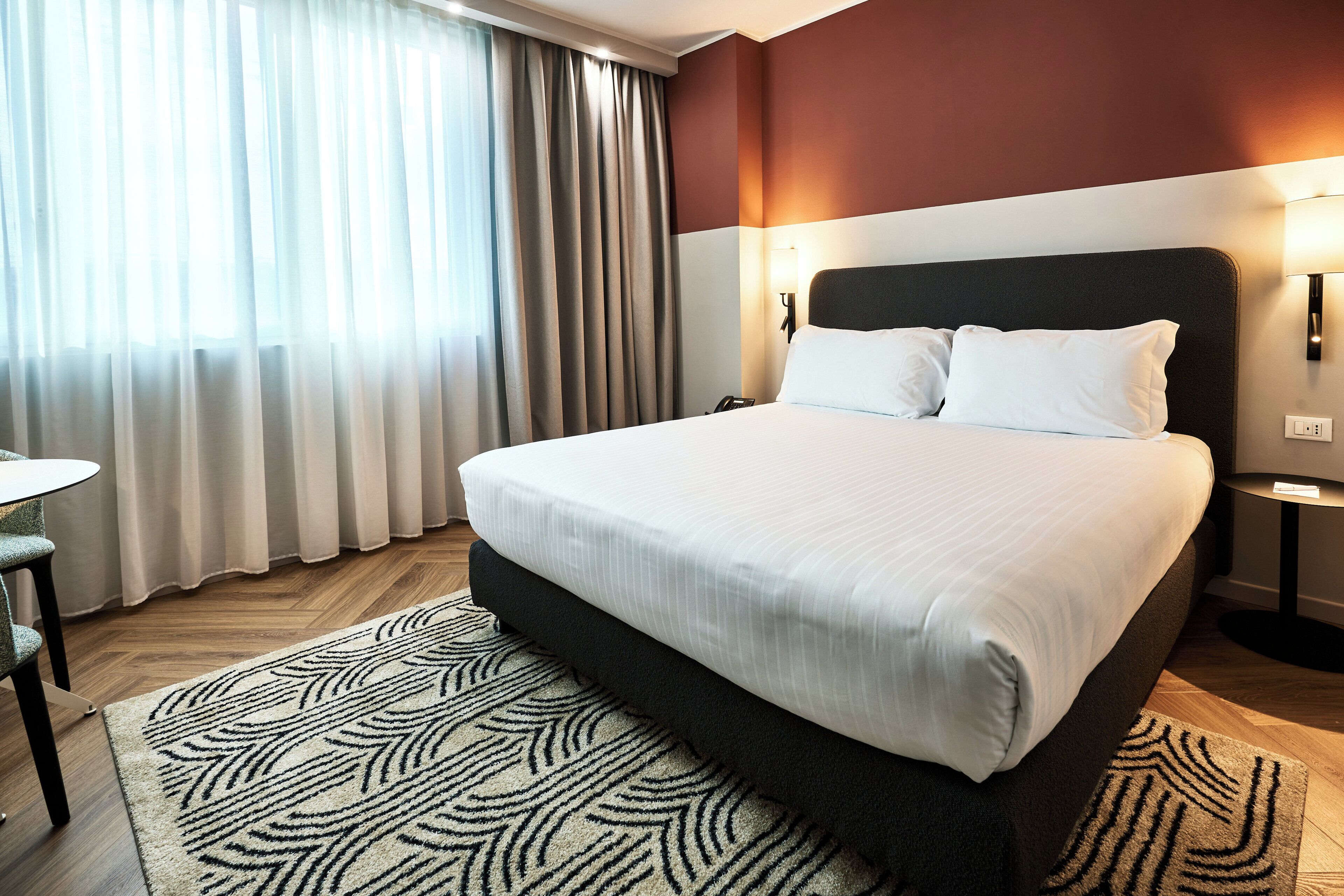 Una habitación de hotel con una cama grande, un escritorio y una silla.
