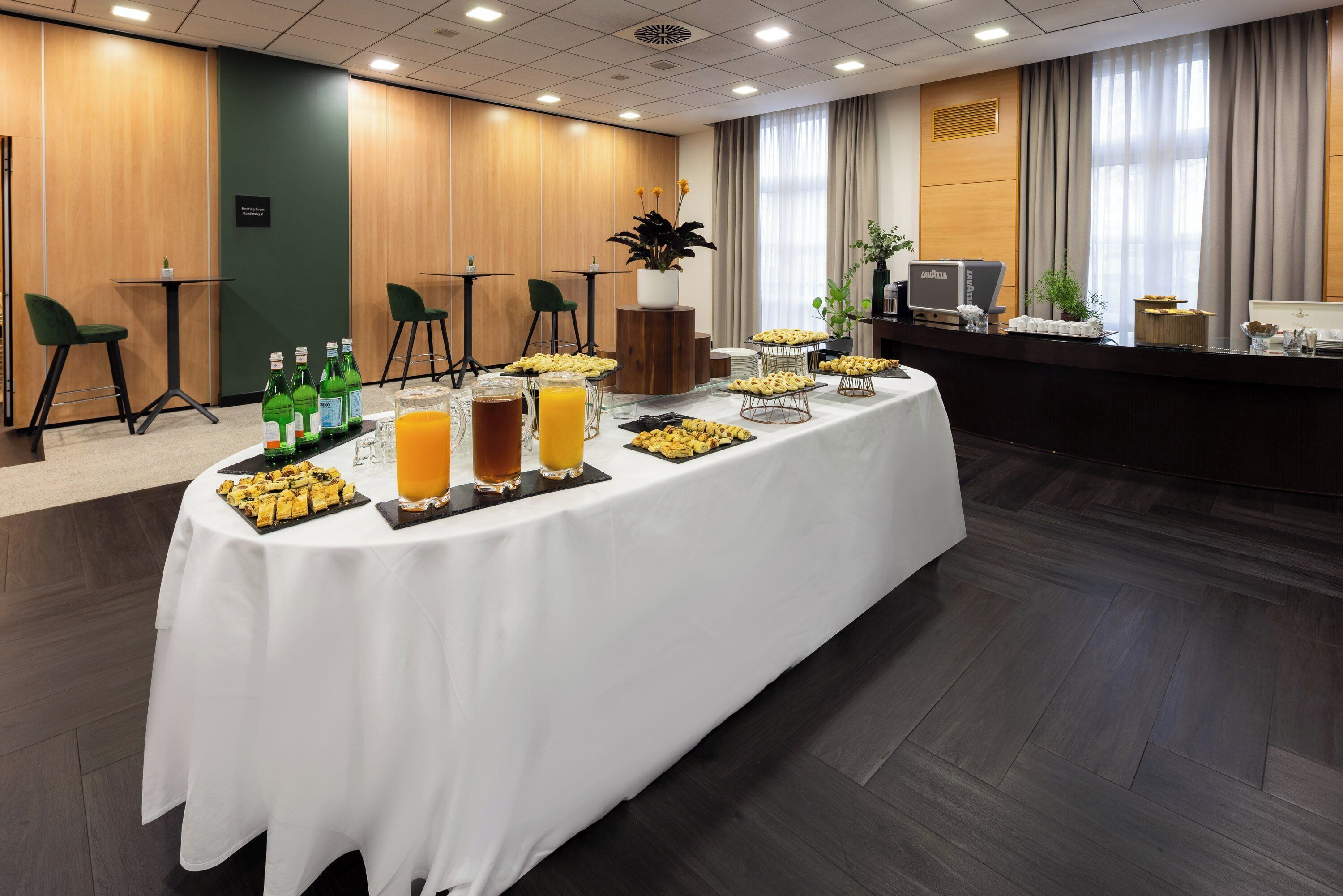 Een vergaderruimte met een lange tafel gedekt voor een buffet, inclusief diverse gerechten en drankjes.