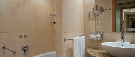 Un baño con una bañera, un lavabo y un espejo.