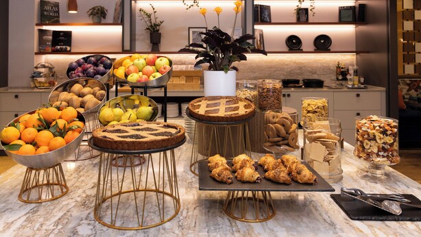 A buffet table with various food items and a modern kitchen in the background. - Crowne Plaza Padova by IHG (Padova)