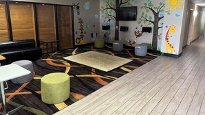 A conference room with a large table, a sofa, and a carpeted floor. - Wingate by Wyndham Warner Robins (Warner Robins)