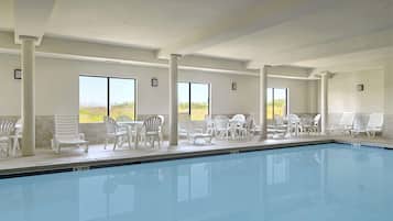 Una piscina techada, sillones reclinables de piscina