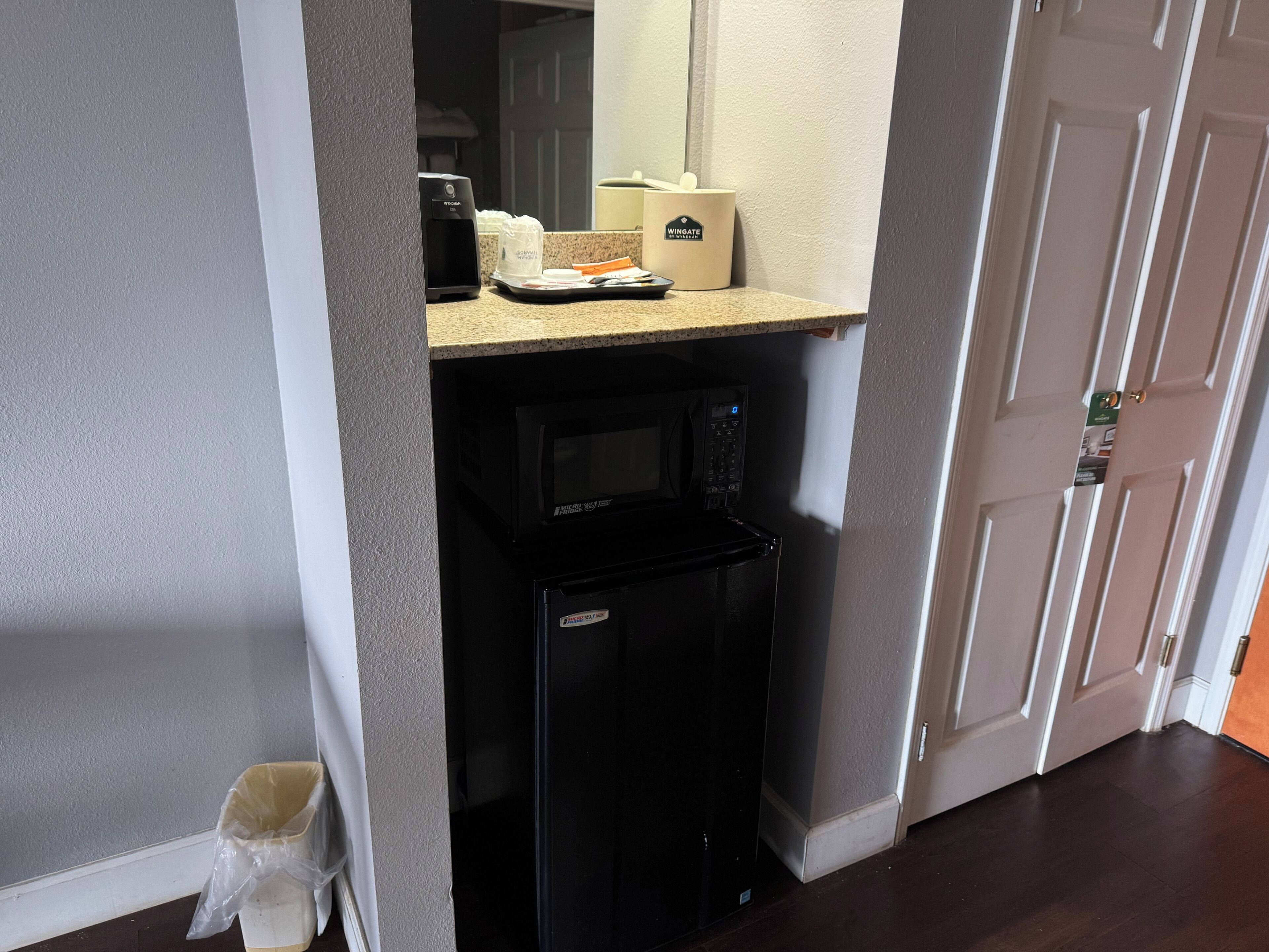 A compact kitchenette with a microwave, coffee maker, and a small refrigerator.