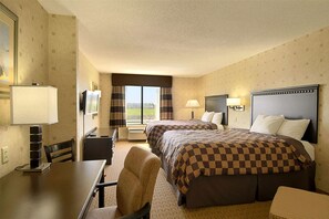 A hotel room with two beds, a desk, a chair, a TV, and a window with curtains. - Wingate by Wyndham Warner Robins (Warner Robins)