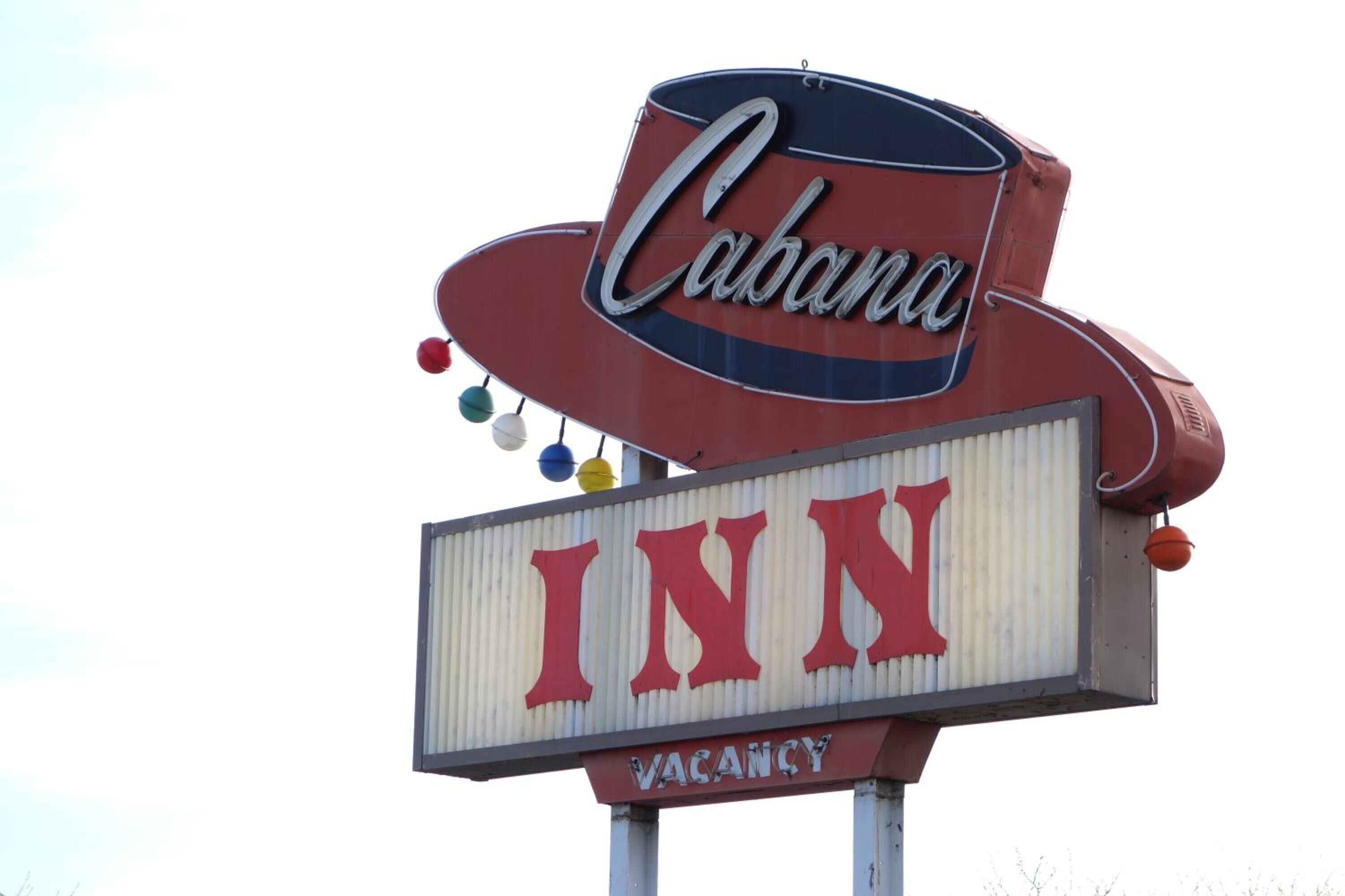 Un letrero que dice 'Cabana INN' con un aviso de 'HABITACIONES DISPONIBLES'.