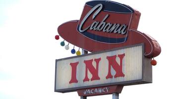 A sign for 'Cabana INN' with a 'VACANCY' notice.