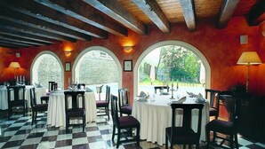 A dining area with tables set for service, large arched windows, and a checkered floor. - Hotel Roma Imperiale (Acqui Terme)