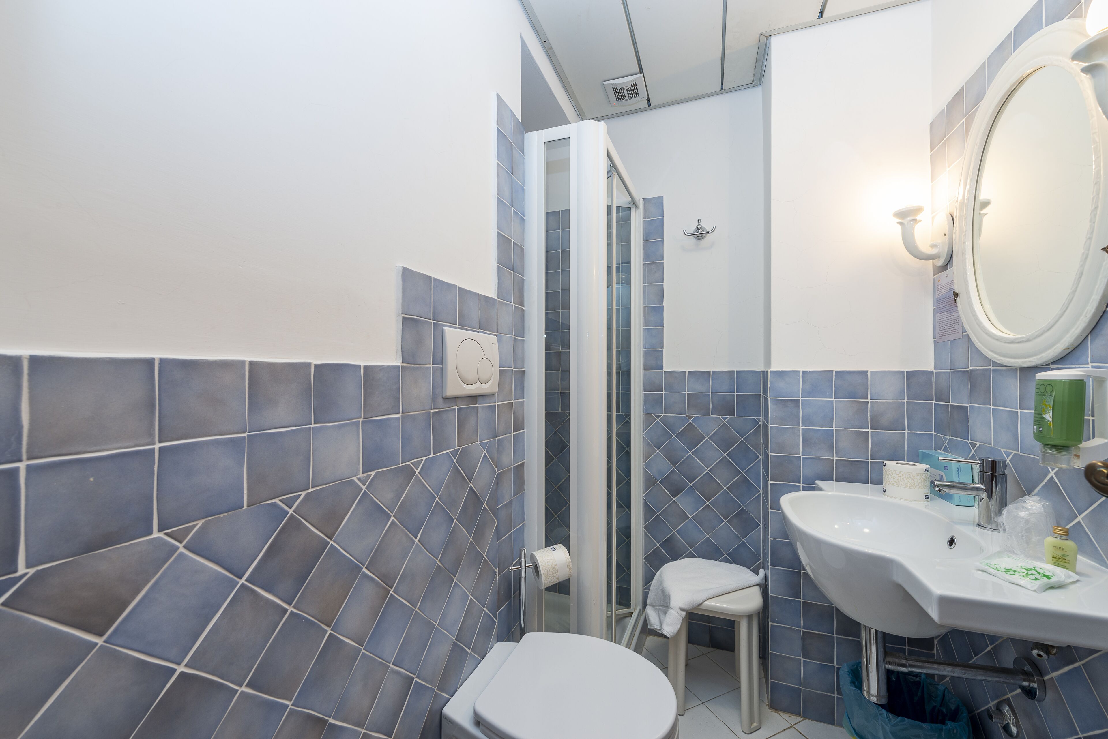 A bathroom with a white toilet, a sink, and a mirror.
