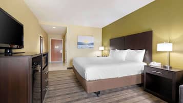 Habitación de hotel con una cama grande, televisión, escritorio con lámpara y un cuadro en la pared.