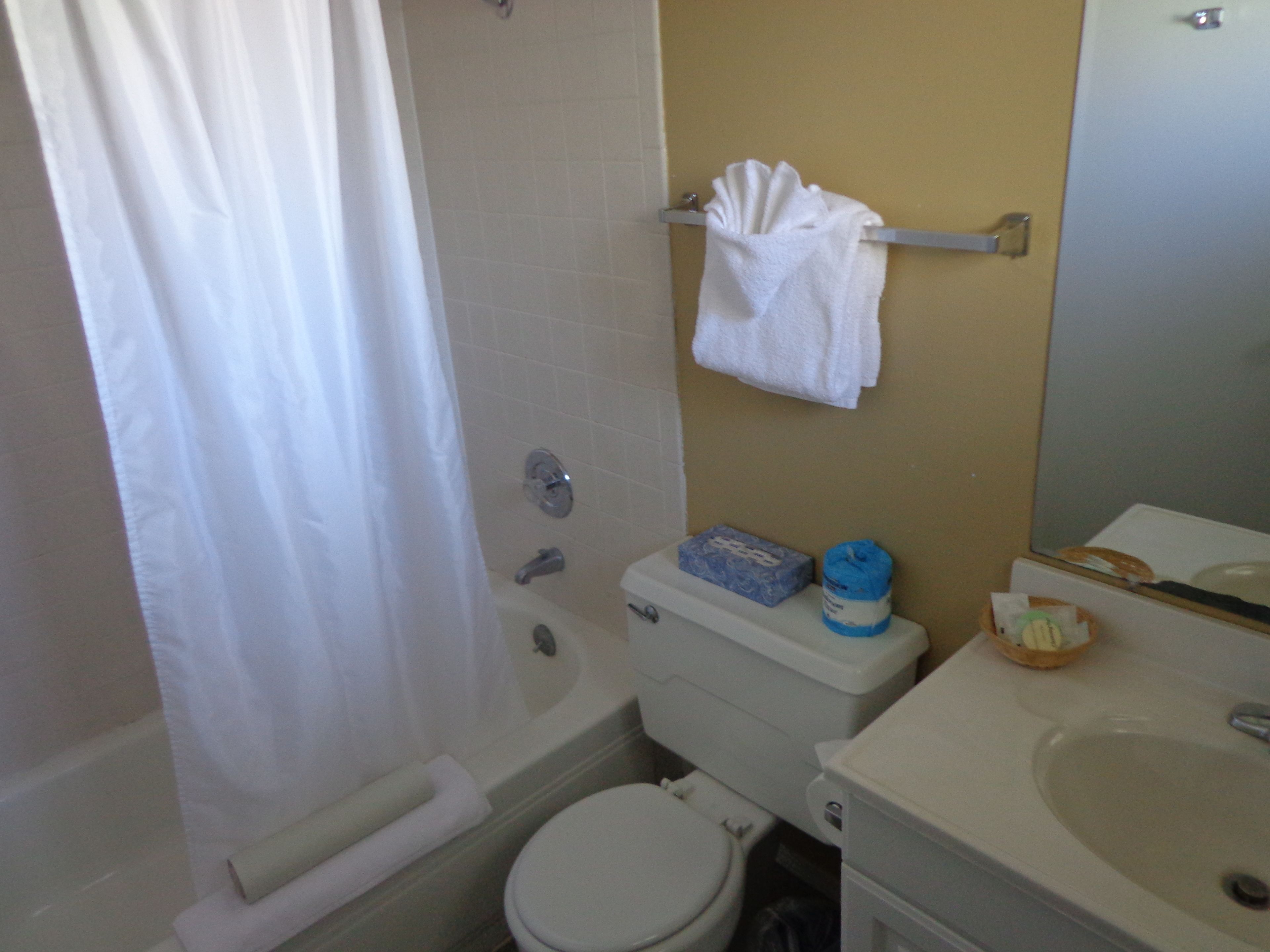 Ein Badezimmer mit einer Badewanne, Toilette, Waschbecken und einem Handtuchhalter mit einem weißen Handtuch.