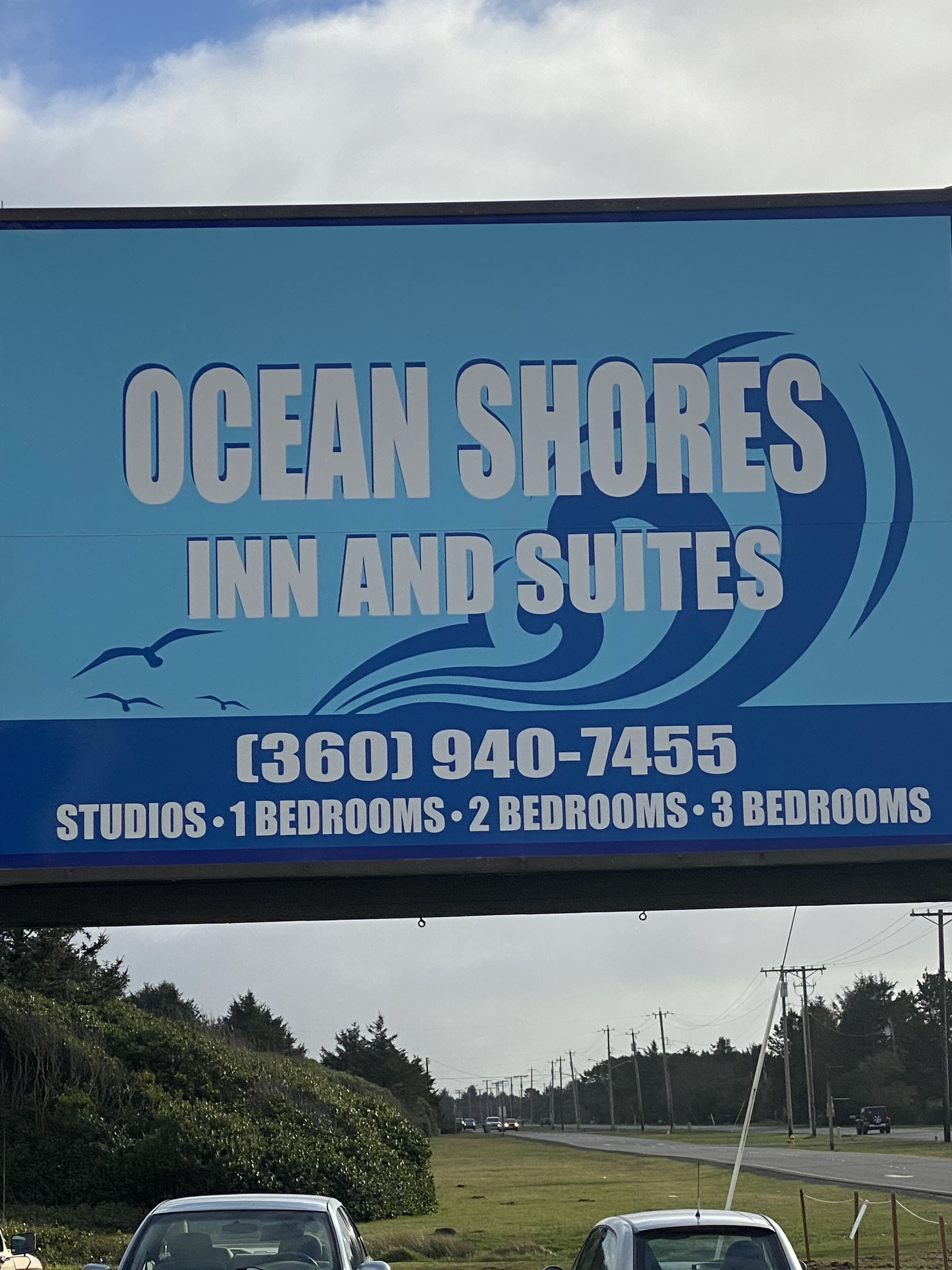 Un anuncio de Ocean Shores Inn and Suites que ofrece estudios, habitaciones de un dormitorio, dos dormitorios y tres dormitorios.